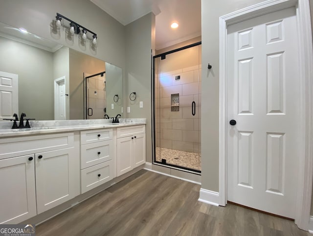 bathroom featuring ornamental molding, hardwood / wood-style flooring, vanity, and an enclosed shower