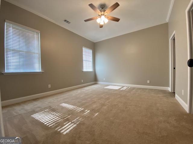 unfurnished room featuring ceiling fan, light carpet, and ornamental molding