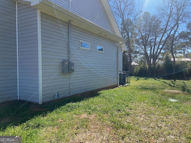 view of property exterior featuring central AC unit and a lawn