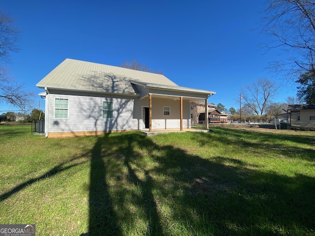 rear view of property with a lawn and a patio