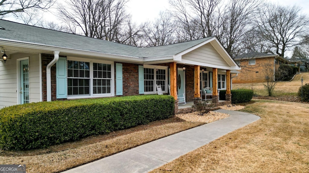 ranch-style home featuring a front yard and covered porch