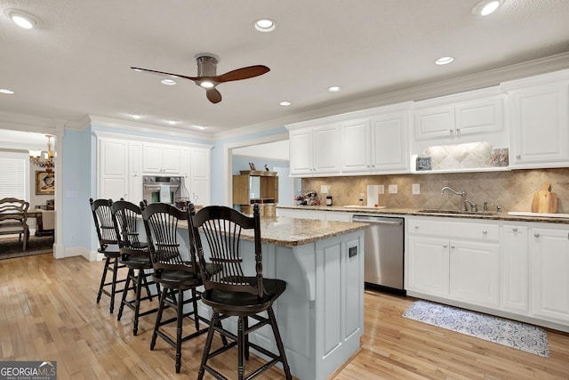 kitchen with stainless steel appliances, sink, white cabinets, and dark stone counters