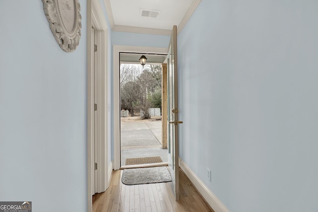 entryway featuring ornamental molding and light wood-type flooring