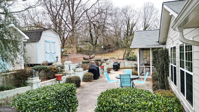 view of patio / terrace featuring a shed, a sunroom, and area for grilling