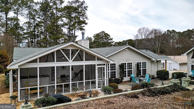 rear view of property featuring a sunroom and a patio area