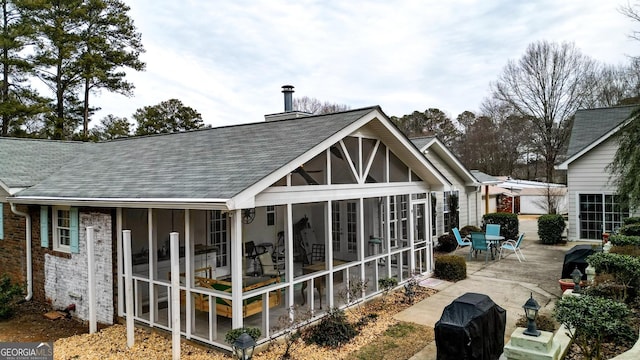 rear view of house with a sunroom and a patio