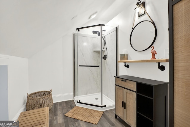 bathroom featuring a shower with door, vaulted ceiling, hardwood / wood-style floors, and vanity