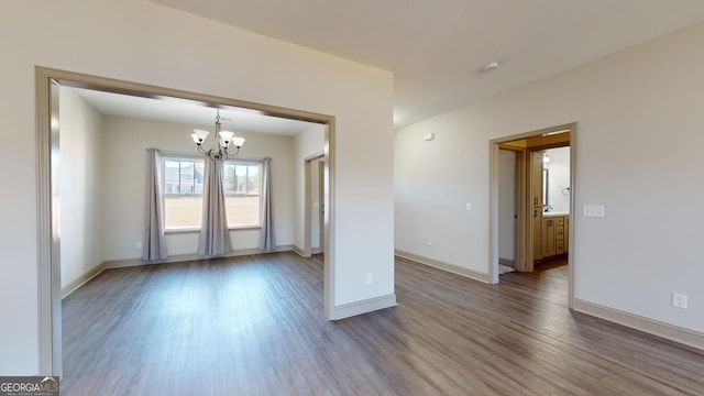 spare room with a chandelier and hardwood / wood-style flooring