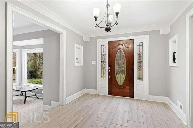 foyer with crown molding and a chandelier