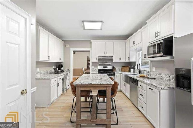 kitchen featuring light stone counters, sink, white cabinets, and stainless steel appliances