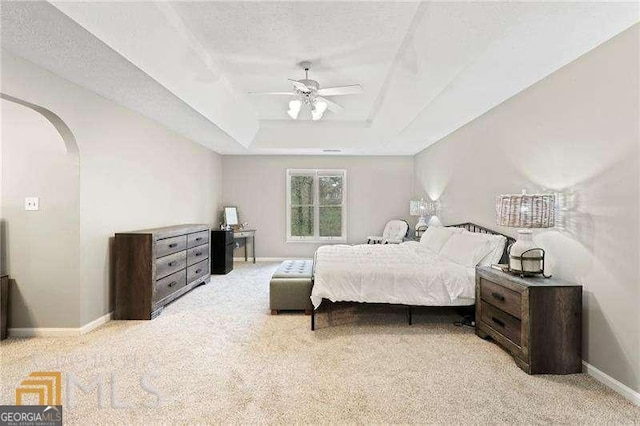 carpeted bedroom featuring ceiling fan, a textured ceiling, and a raised ceiling