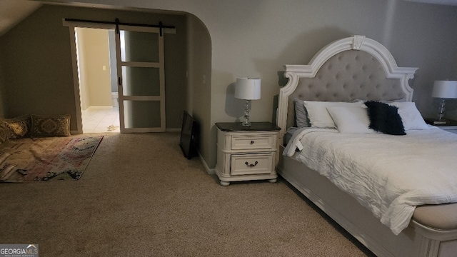 bedroom featuring lofted ceiling, light carpet, and a barn door