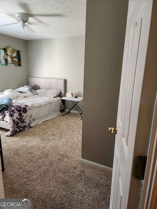 bedroom featuring a textured ceiling, ceiling fan, and carpet flooring