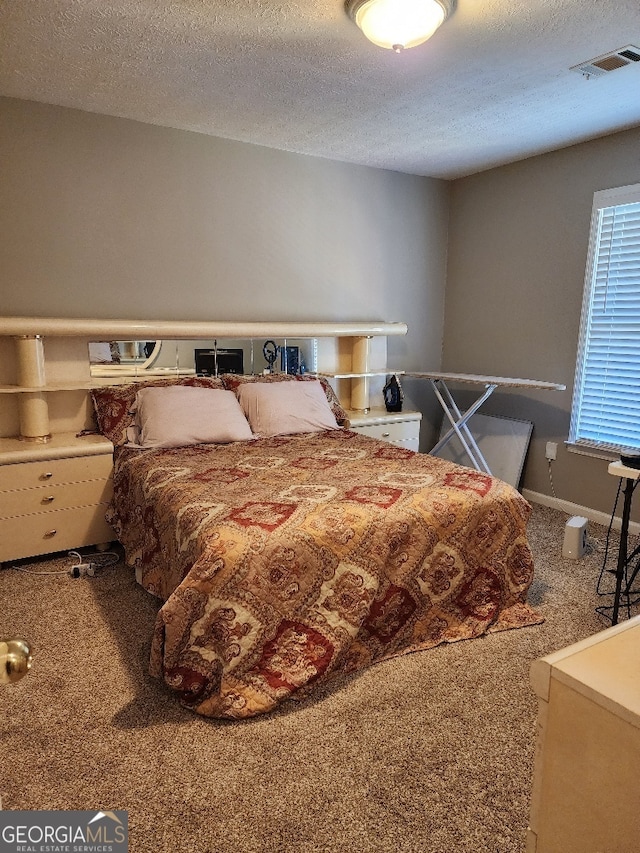 carpeted bedroom featuring a textured ceiling