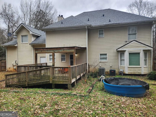 rear view of house featuring central AC unit and a deck