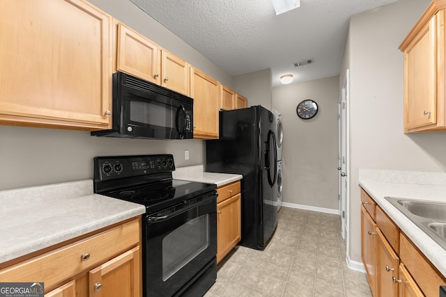 kitchen with black appliances, light brown cabinetry, sink, and a textured ceiling