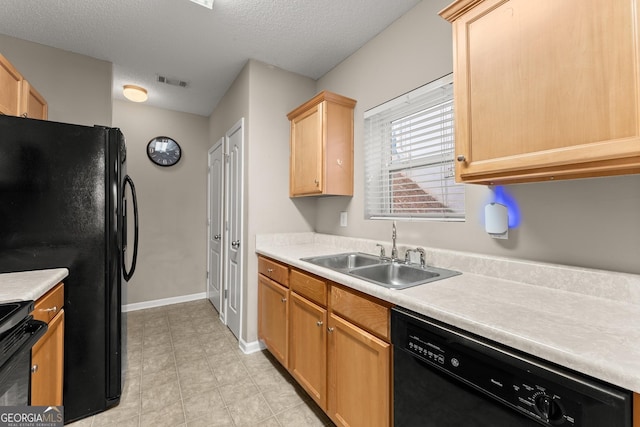 kitchen featuring a textured ceiling, light brown cabinetry, black appliances, and sink