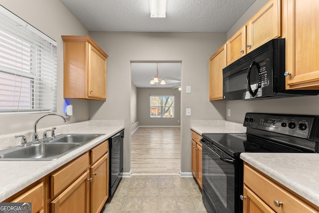 kitchen featuring black appliances, sink, a textured ceiling, and pendant lighting