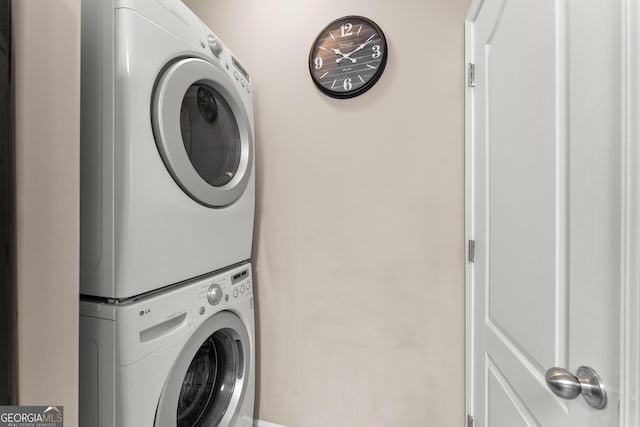 clothes washing area featuring stacked washer and dryer