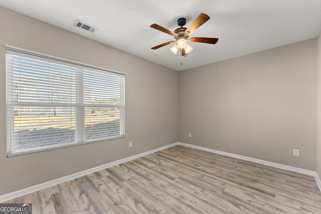 spare room with ceiling fan, a textured ceiling, and light hardwood / wood-style flooring