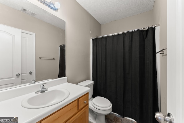 bathroom with a textured ceiling, toilet, and vanity