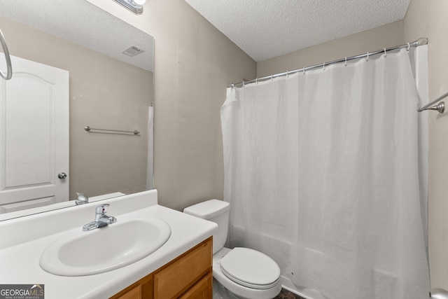 bathroom featuring a textured ceiling, toilet, and vanity