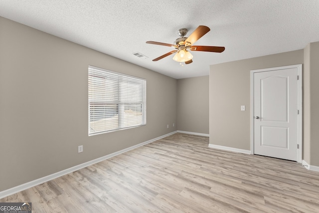 unfurnished room with a textured ceiling, ceiling fan, and light wood-type flooring