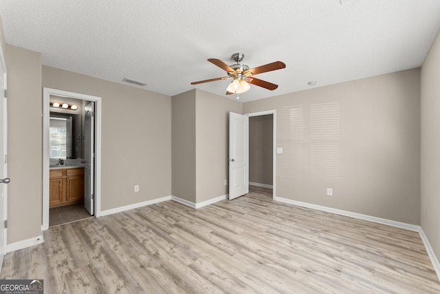 unfurnished bedroom featuring light hardwood / wood-style floors, ceiling fan, ensuite bath, a textured ceiling, and sink