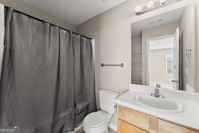 bathroom featuring a textured ceiling, toilet, and vanity