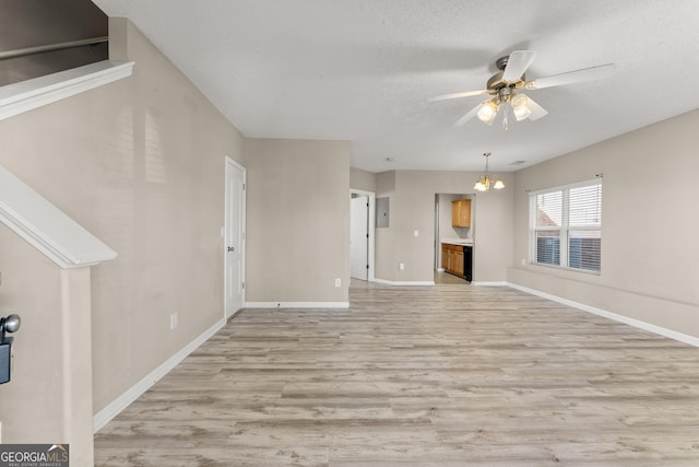 unfurnished living room with ceiling fan with notable chandelier, a textured ceiling, electric panel, and light hardwood / wood-style flooring