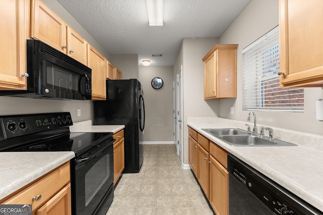 kitchen with a textured ceiling, sink, light brown cabinets, and black appliances