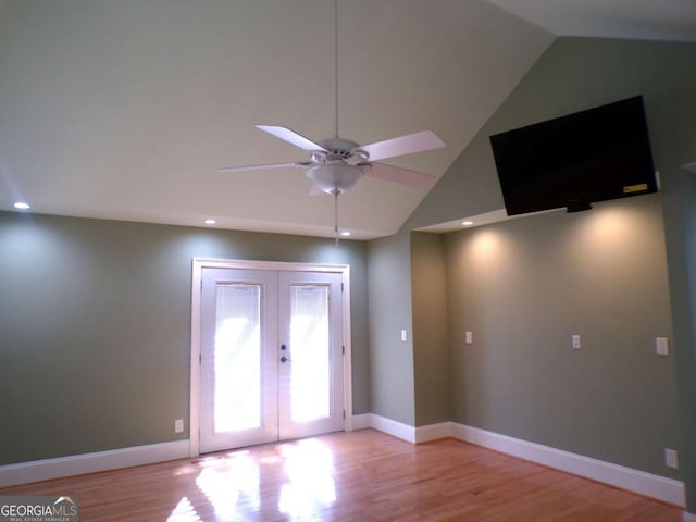 empty room featuring ceiling fan, french doors, vaulted ceiling, and light hardwood / wood-style floors