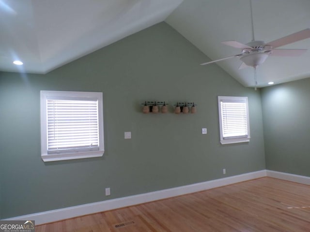 empty room featuring vaulted ceiling, ceiling fan, and light hardwood / wood-style flooring