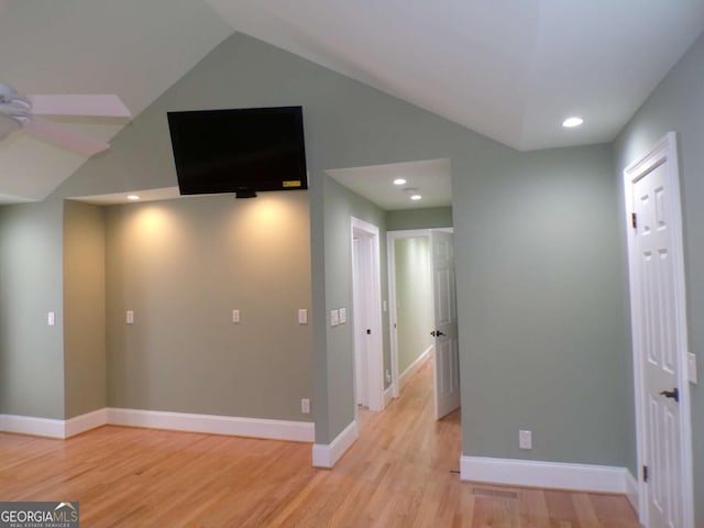 hallway with light hardwood / wood-style flooring and vaulted ceiling