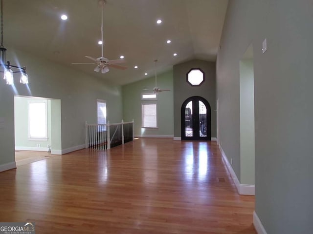 entryway with a healthy amount of sunlight, a towering ceiling, and light hardwood / wood-style floors