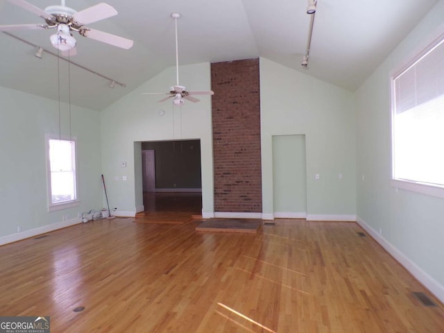 unfurnished living room with lofted ceiling, light wood-type flooring, ceiling fan, and rail lighting