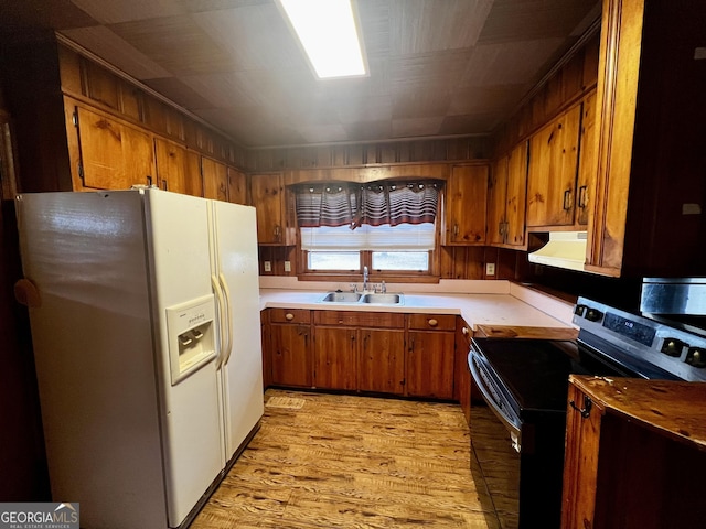 kitchen featuring sink, white refrigerator with ice dispenser, light hardwood / wood-style flooring, and range with electric stovetop