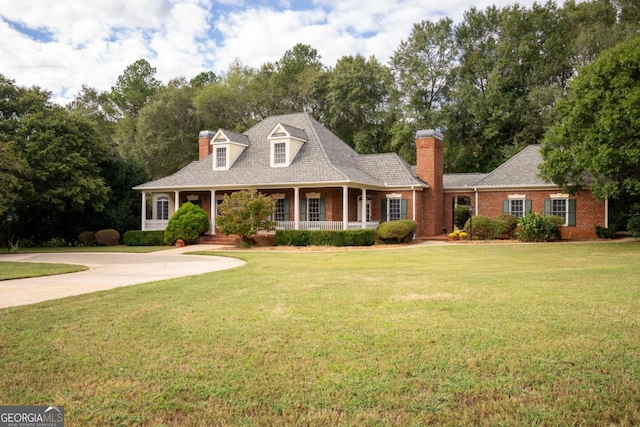 new england style home featuring a front yard and a porch