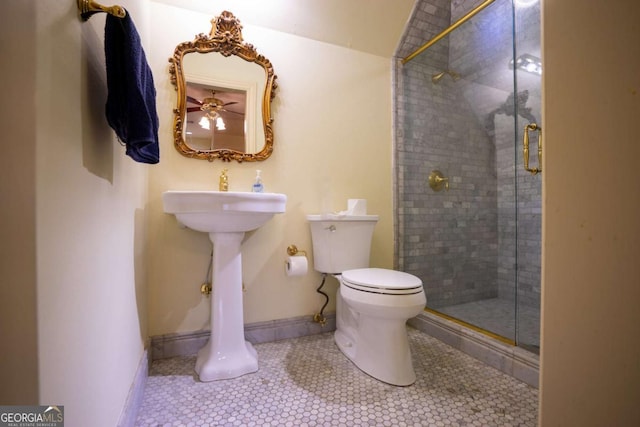 bathroom featuring toilet, tile patterned floors, and a shower with shower door