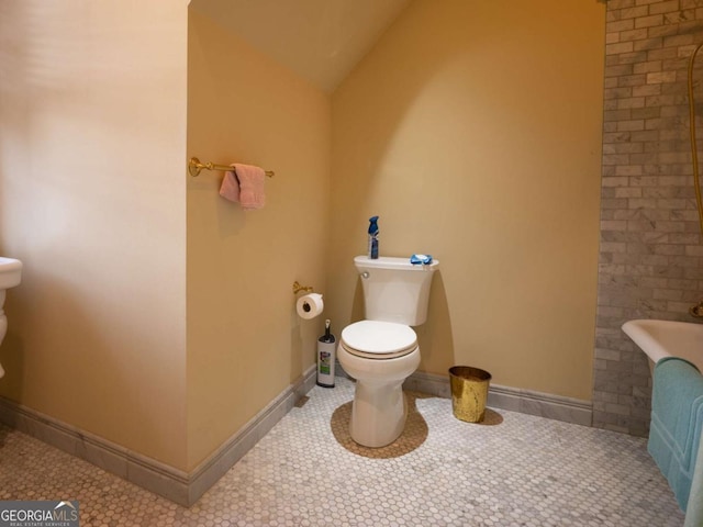 bathroom with toilet, tile patterned floors, and lofted ceiling