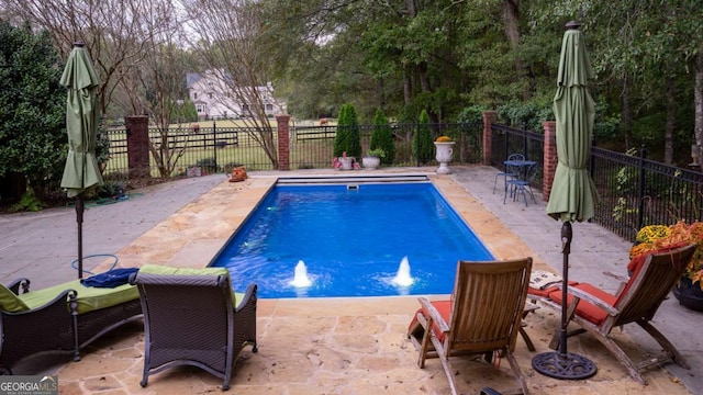 view of pool featuring pool water feature and a patio