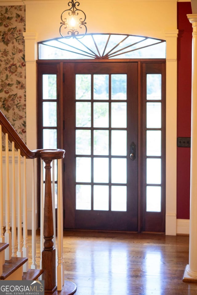 foyer entrance featuring wood-type flooring, french doors, and decorative columns