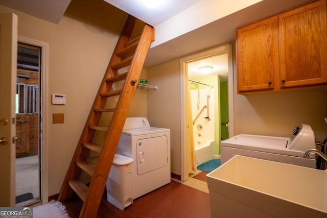 washroom with sink, washing machine and clothes dryer, and cabinets