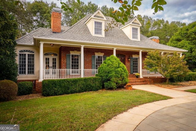 cape cod-style house featuring a front yard and a porch