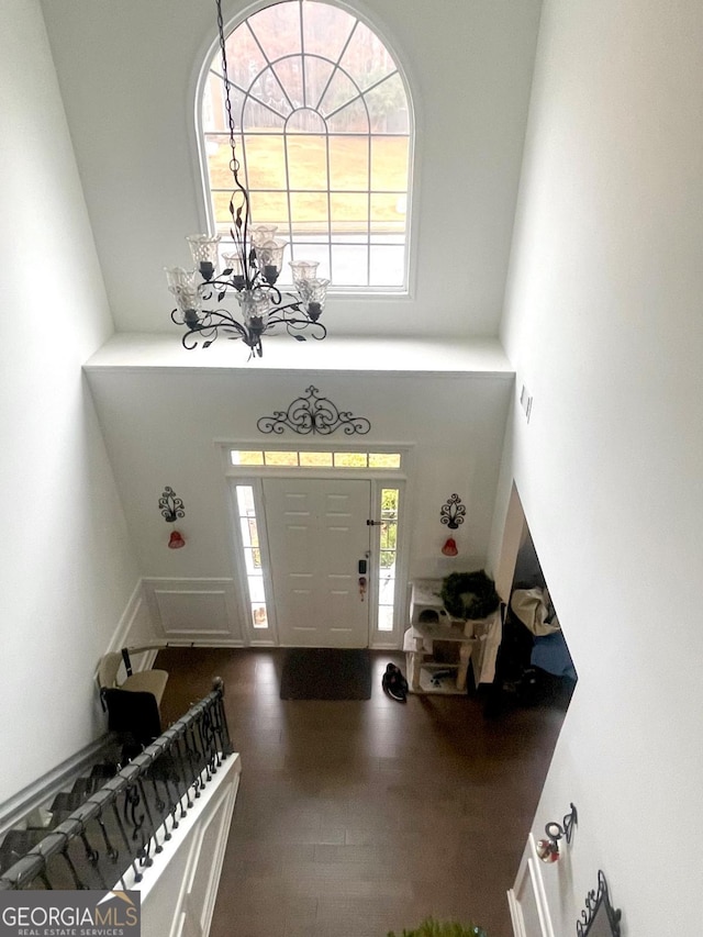 entryway featuring an inviting chandelier, a healthy amount of sunlight, and a towering ceiling