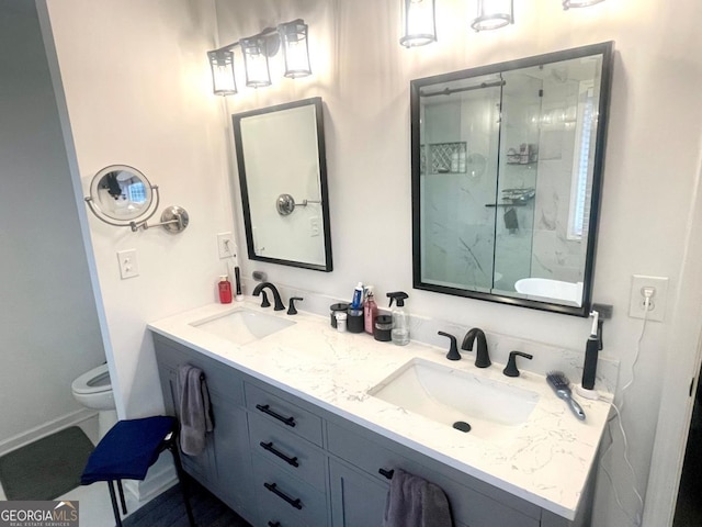 bathroom with toilet, vanity, and a shower with shower door