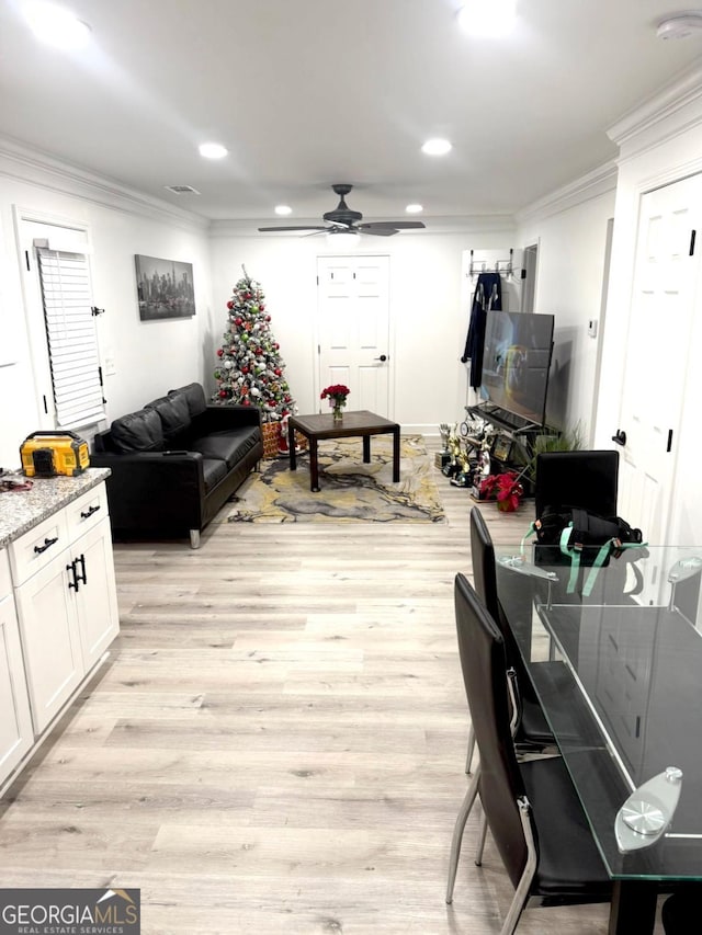 living room featuring light hardwood / wood-style floors, crown molding, and ceiling fan