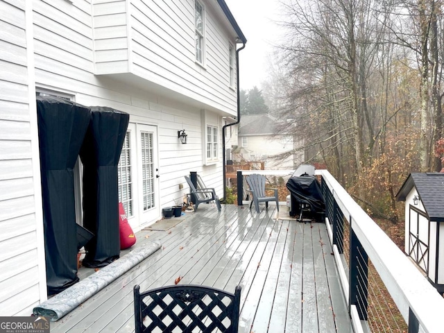 wooden terrace featuring a grill