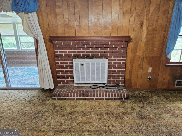 details featuring carpet floors, central AC unit, a brick fireplace, and wooden walls