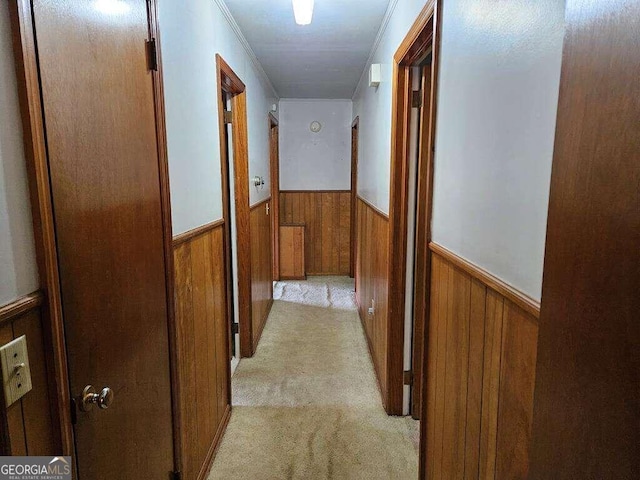 hallway featuring ornamental molding and light carpet